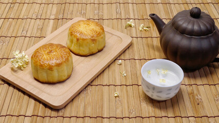 Teapot and moon cake on bamboo table. Concept for Mid-Autumn Festival or Moon Festival, a traditional holiday in East Asia. Chinese words on moon cake is