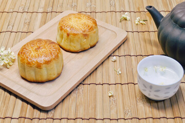 Teapot and moon cake on bamboo table. Concept for Mid-Autumn Festival or Moon Festival, a traditional holiday in East Asia. Chinese words on moon cake is
