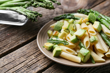 Plate of tasty pasta with vegetables on wooden background, closeup