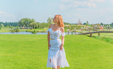 Fototapeta na wymiar Lady in white cotton suit, crop top and skirt at nature, vacation scene