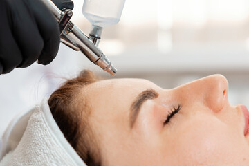 Fototapeta premium Beauty procedure of a gas-liquid oxygen water epidermal peeling using hardware apparatus to the client's face. Close up. Concept of cosmetology