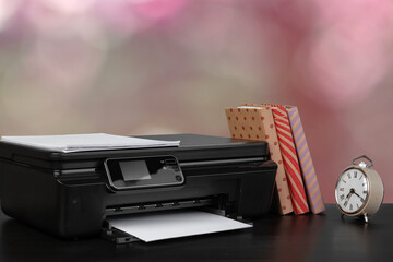 Stack of books and home printer against blurred background