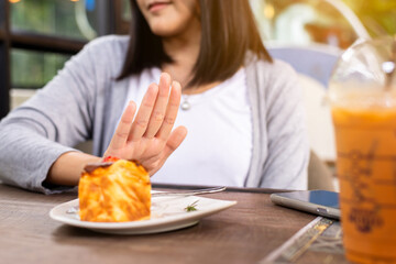 Hands woman refusing cake or junk food in restaurant,No meal,Diet food concept