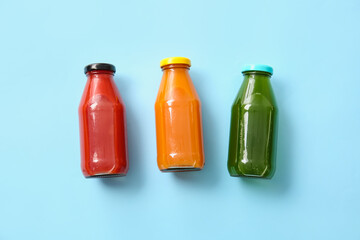 Bottles with healthy juice on color background
