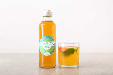 Bottle and glass of tasty kombucha tea on table