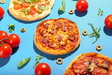 Tasty mini pizzas on color background