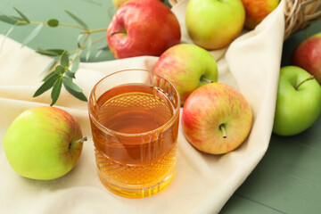 Glass of tasty apple juice on color wooden background, closeup