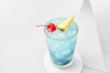 Glass of Blue Lagoon cocktail on light background
