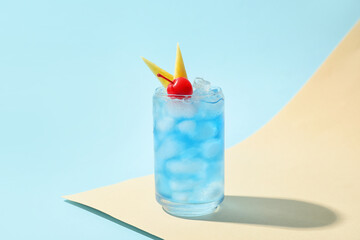Glass of Blue Lagoon cocktail on color background