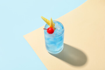 Glass of Blue Lagoon cocktail on color background