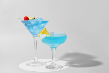 Glasses of Blue Lagoon cocktail on light background