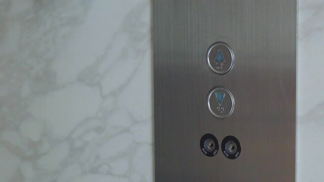 Finger pressing elevator button close up