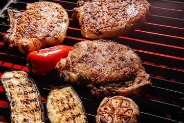 Tasty pork steaks and vegetables on barbecue grill
