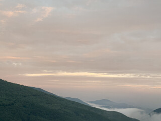 a beautiful view of mountains with clouds at dawn