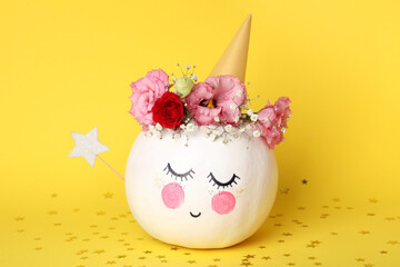 Сute pumpkin with halloween makeup on yellow background