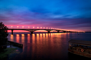 Fototapeta na wymiar Night river before beautiful sunrise. Light on bridge.