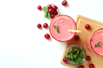 Glasses of cherry smoothie and ingredients on white table