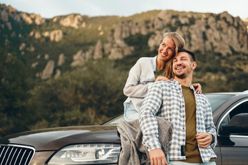 Young couple is on romantic trip to the mountains by car