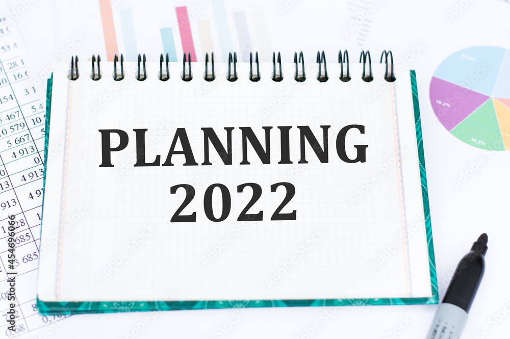 Aufkleber planning 2022 text on a notebook on the table. plans for the new year