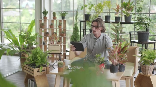 men is using tablet to sell online of his plant in his green house garden for retirement lifestyle concept