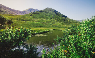Beautiful landscape scenery of river and green mountains in the background at, Loch Na Fooey in connemara, county Galway, Ireland 