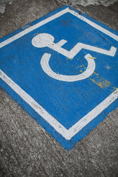 A blue handicap sign on a street.