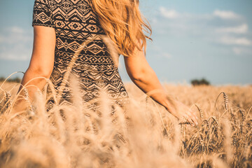 happy beautiful young woman walking on wheat field with ripe spikelets, girl breathe breathes...