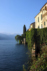 Fototapeta na wymiar Old houses overlook Orta Lake, in Piedmont, North-West Italy from the shores of San Giulio Island