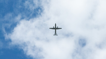 View of propeller plane flying with blue sky and clouds. Airplane fly