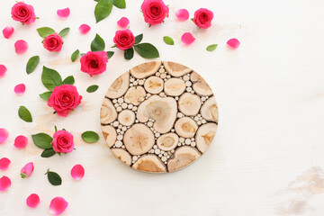 White wooden delicate background with pink roses and petals. Top view