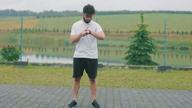 a man presses his watch and looks at it