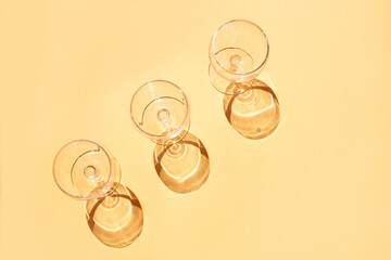 Wine glasses on a beige background. Flat lay style, top view. Contrasting shadows trend, sunny day