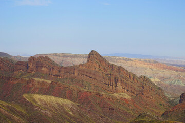 Hills formed by erosion of colored rocks with reddish-yellow and orange stripes.