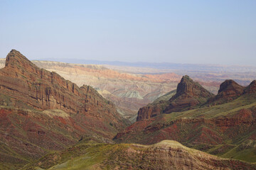 Hills formed by erosion of colored rocks with reddish-yellow and orange stripes.