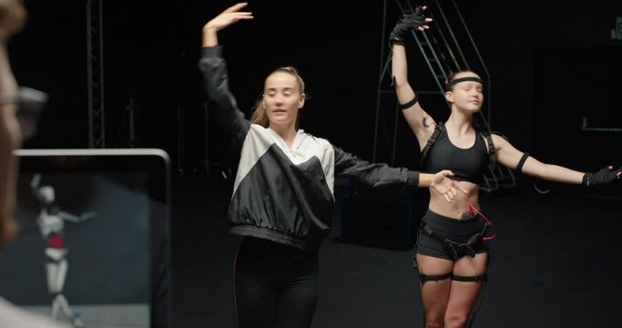 dancing woman wearing motion capture suit rehearsing ballet dance with instructor girl wearing mo-cap suit for 3d character animation for virtual reality technology