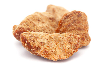 Micro close-up and details of Organic Indian sugarcane jaggery piece (gud) (Saccharum officinarum)  isolated over white background.