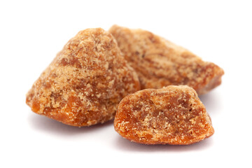 Micro close-up and details of Organic Indian sugarcane jaggery piece (gud) (Saccharum officinarum)  isolated over white background.