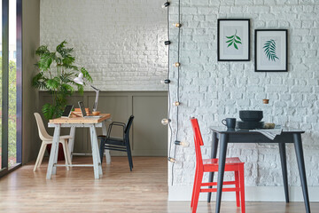 Black kitchen table, chair and plate in the white brick wall, modern living room background, working table, bookshelf concept, home living room interior style.