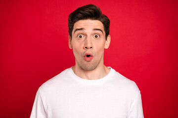 Photo of impressed brunet young guy wear white shirt isolated on red color background