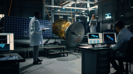 Engineer and Technician Working on Satellite Construction. Aerospace Agency: Diverse Team of Scientists Using Technological Equipment and Laptop Computer to Develop Spacecraft for Space Exploration.