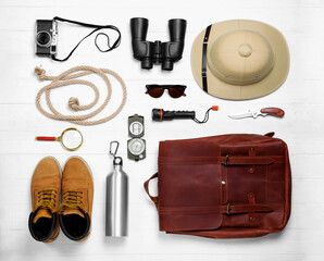 Flat lay composition with different safari accessories on white wooden background © New Africa