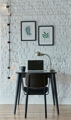 working table, white brick wall background, decorative lamp, laptop and computer style, frame notebook hang.