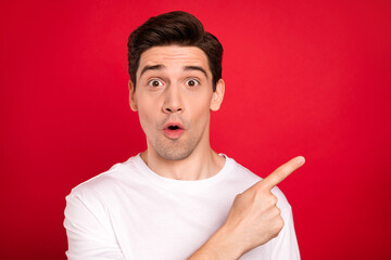 Photo portrait brunet wearing casual t-shirt amazed pointing finger copyspace isolated bright red...