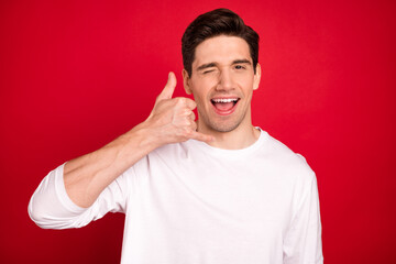 Photo of funny brunet young guy hands call me wear white shirt isolated on red color background