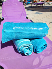 Close-up of bright blue towels on a chaise longue wrapped in stretch film, security measures...