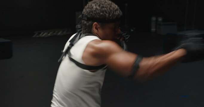 man wearing motion capture suit in studio performing martial arts actor boxing wearing mo-cap suit for 3d character computer game animation for virtual reality fighting gaming