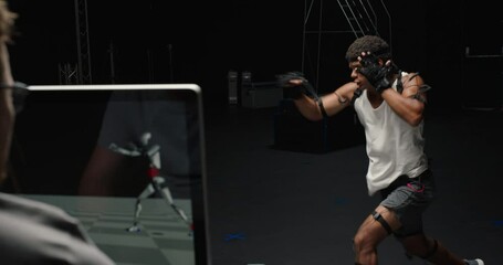man wearing motion capture suit in studio performing martial arts actor boxing wearing mo-cap suit for 3d character computer game animation for virtual reality fighting gaming