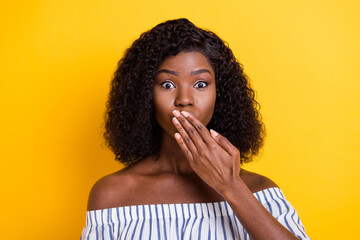 Fototapeta na wymiar Photo of attractive dark skin lady arm covering mouth lips look worried camera isolated on yellow color background