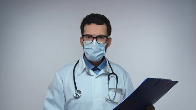 Doctor says NO, disagreement, stop. Frightened worried man doctor on white background looking at camera and starts waving his hands nervously, shouting no-no-no