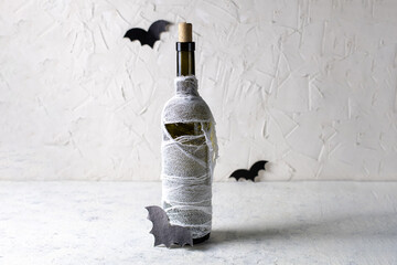 Bottle of cocktail decorated as mummy. Drink for a halloween party